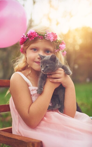 Photo girl portrait and hug with kitten for love or furry companion for comfort friendship and growth or development kid flower crown and cute animal in nature with affection bonding and playing