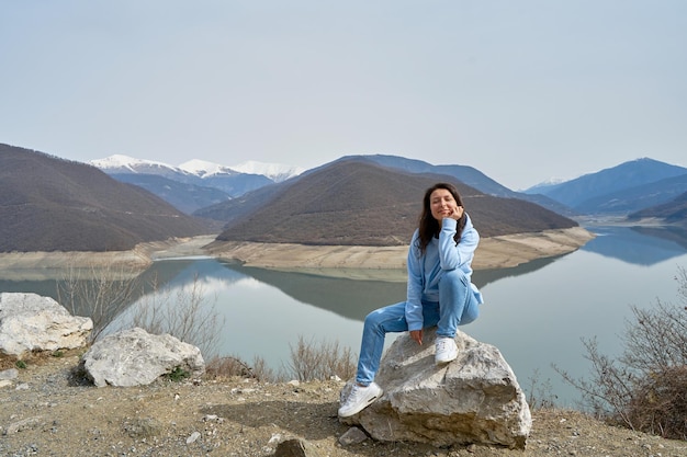 A girl poses against the background of the Zhinvali reservoir while traveling in Georgia Incredible natural landscape