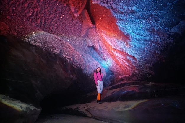 A girl poses inside an ice cave