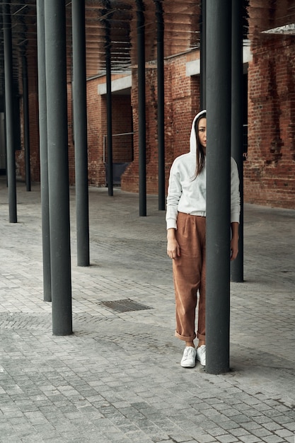 Girl posing on the street near black columns. Walking and entertainment in the city.