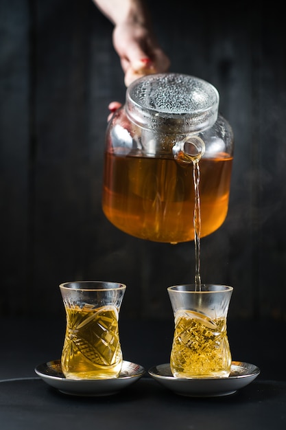 The girl pours tea in an armud