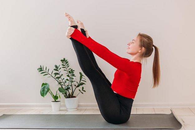 Girl practicing yoga at home Indoor and outdoor workout Sport and healthy active lifestyle concept