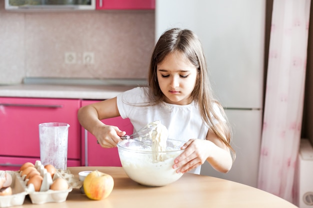 Girl prepare Breakfast, baking, stir in a bowl of flour, milk, eggs, pancakes, children help mother, family Breakfast, cooking