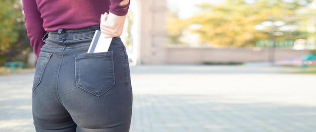 Girl putting credit card in jeans pocket