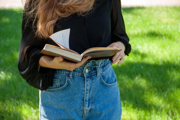 a girl reading a book, book in hands, man in the park, education