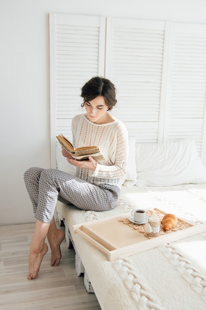 Girl reading a book over Breakfast 