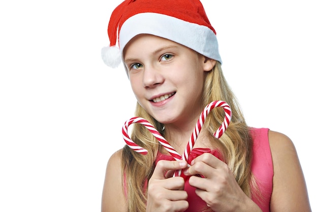 Girl in red cap with christmas candy cane isolated