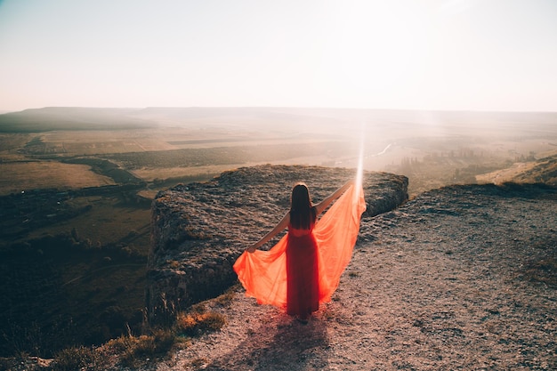 A girl in a red dress on the background of the mountains lifestyle