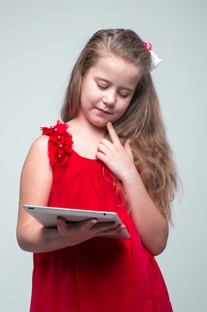 Girl in red dress holding digital tablet