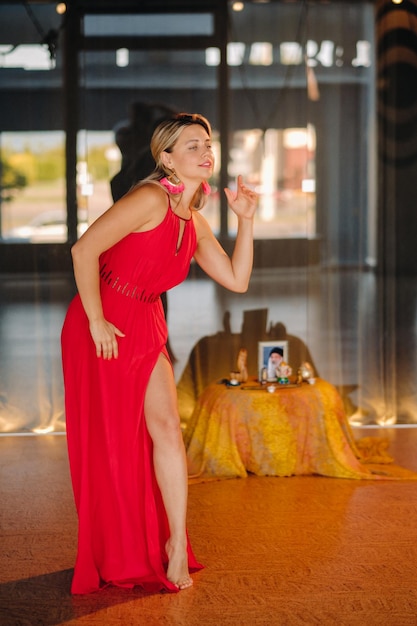 A girl in a red dress moves in a dance meditating indoors Dynamic dance