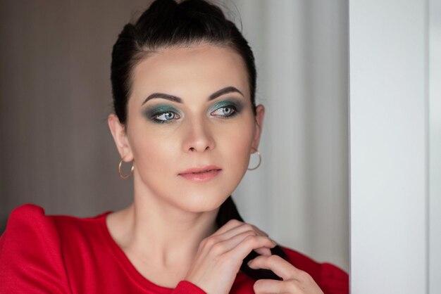 Photo girl in a red dress with makeup. portrait of a young brunette girl. beautiful girl.