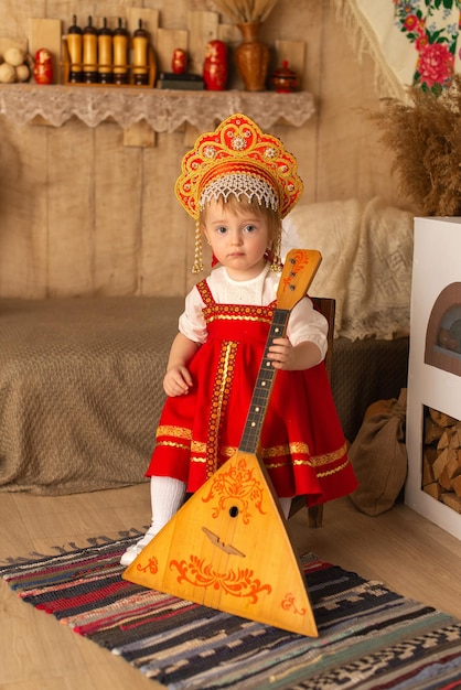 A girl in a red national costume with a balalaika Pancake day