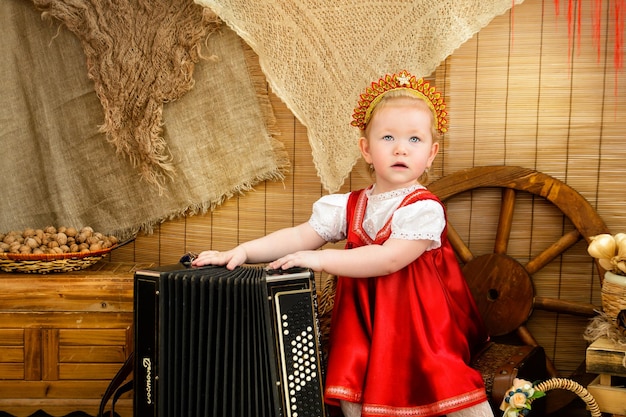 A girl in a red national costume with a boyan Pancake day