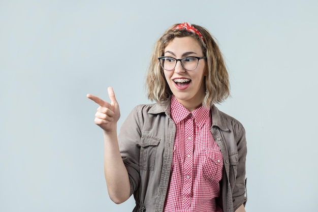 The girl in a red plaid shirt lifts a clenched fist up for joy Success and happiness of the work Successful person victory