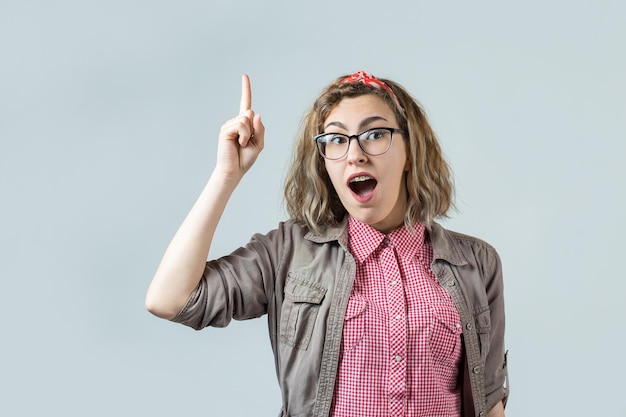 The girl in a red plaid shirt lifts a clenched fist up for joy Success and happiness of the work Successful person victory