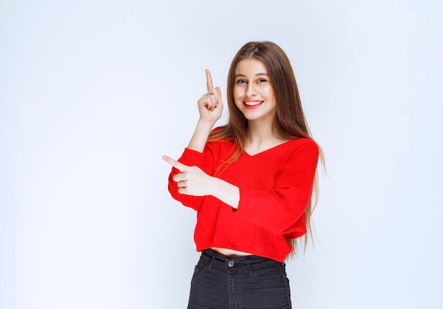 Girl in red shirt showing something upside. 