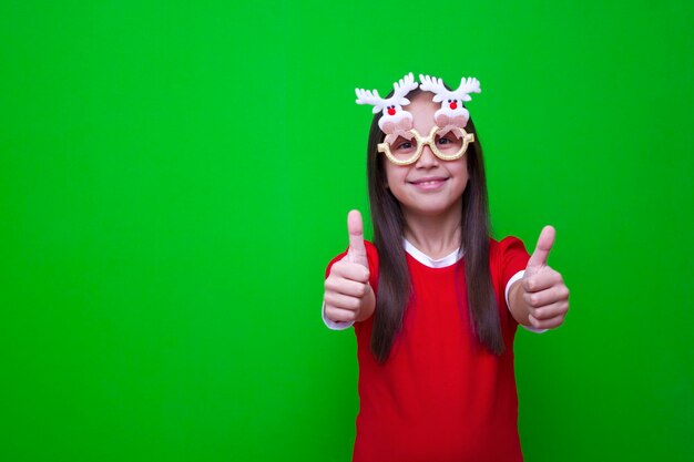 Girl in red tshirt in funny glasses with deer for the christmas holidays new year shows class cool