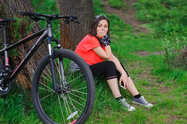 Girl resting after cycling near a tree