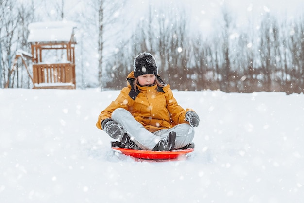 A girl rides down a slide in a winter park a healthy lifestyle a sports walk