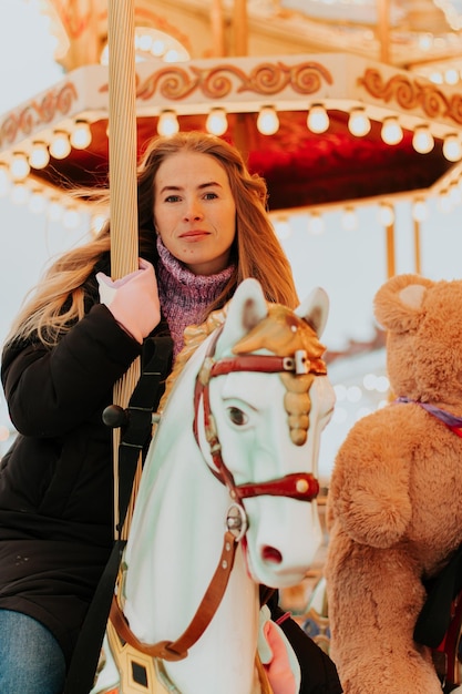 girl riding a carousel with horses