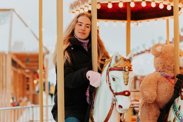 girl riding a carousel with horses