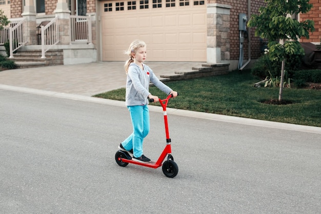 Photo girl riding push scooter on road