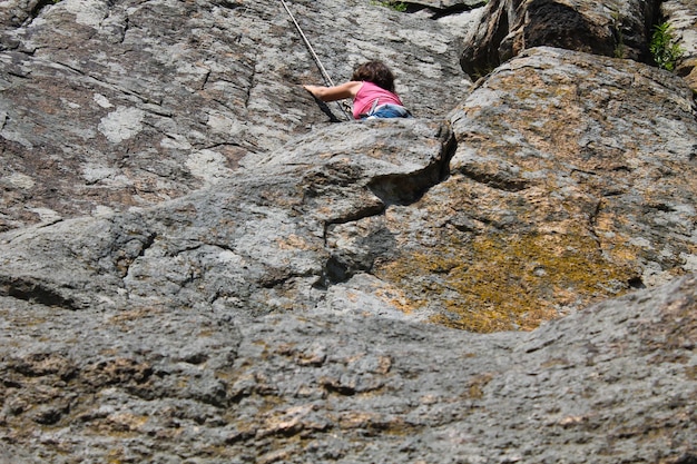 Girl rock climber climbs on a rock