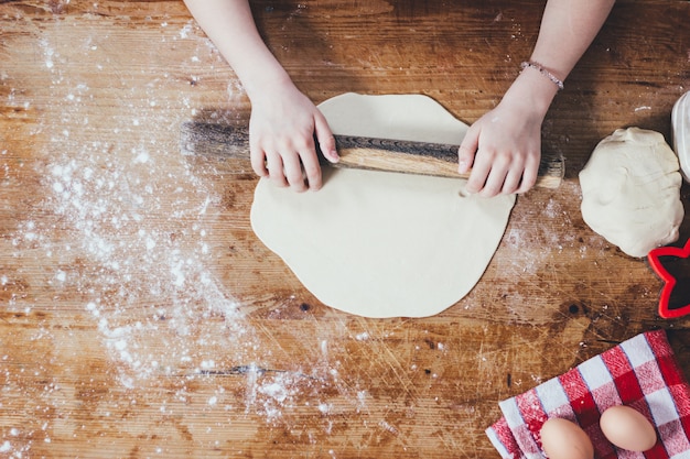 Girl rolling dough with rolling pin