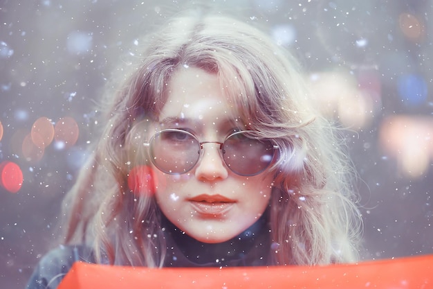 girl romantic portrait first snow autumn, snowflakes blurred background seasonal winter