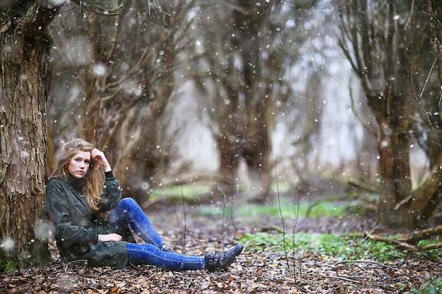 girl romantic portrait first snow autumn, snowflakes blurred background seasonal winter