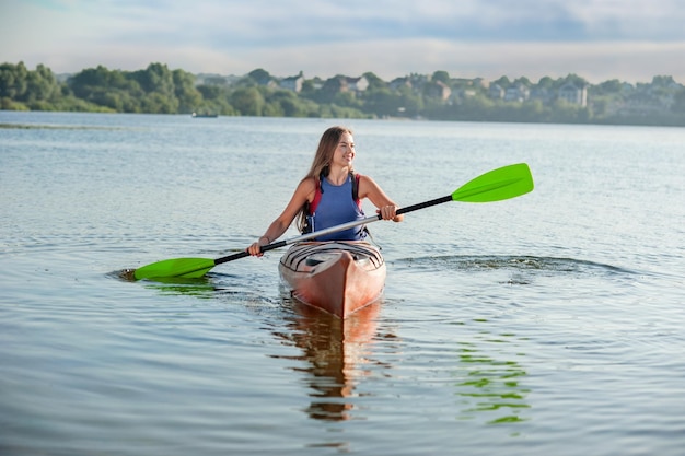 Girl rowing a kayak on the lake A girl in a canoe on a water excursion active pastime