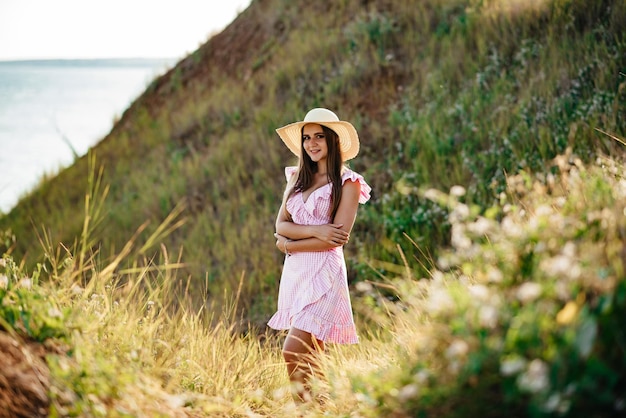 Photo the girl runs across the field happy girl long hair white dress a hat with a brim bouquet of daisies a young girl in nature