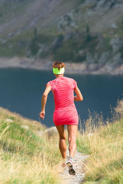 Girl runs to a lake in the mountains