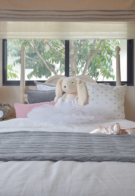 Girl's bedroom with ballet shoes and dolls on bed at home