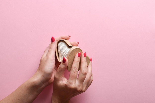 The girl's hands open an ecobox in the shape of a heart A gift for Valentine's Day