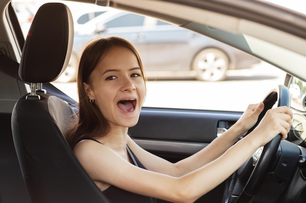 Girl screams at the wheel is afraid to drive a car