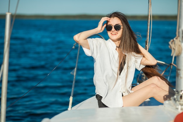 Girl sitting on the bow of a sailboat ship