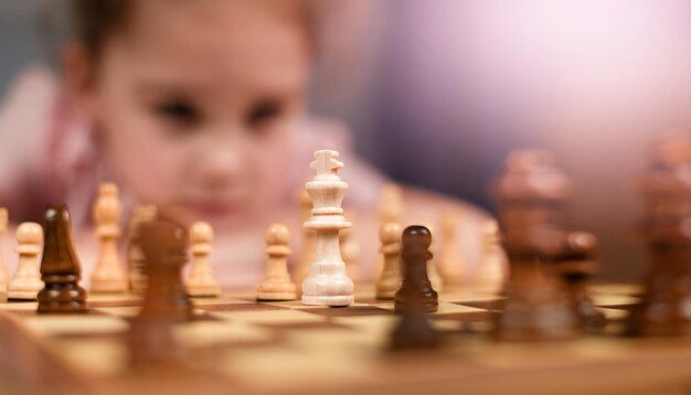 a girl sitting in front of a chessboard and pondering a move