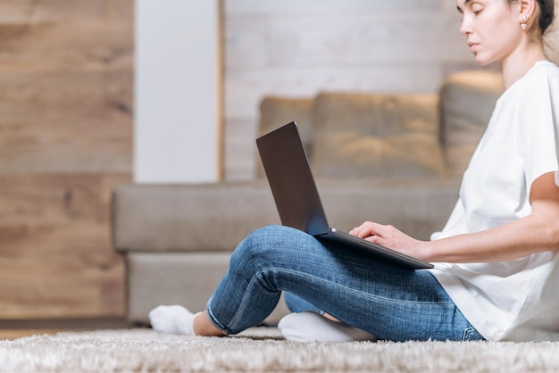 Girl sitting home working and browsing online on laptop