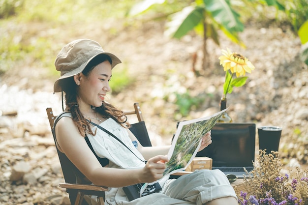 Girl sitting and looking at the map by the stream