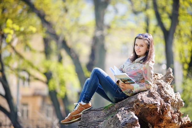 Girl sitting in the park and reading a book