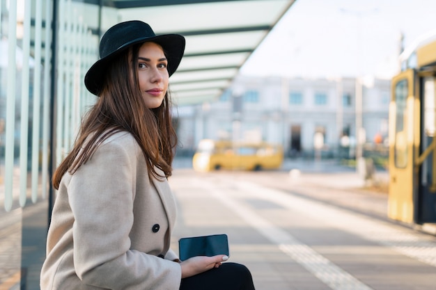 Girl sitting at the public bus stop