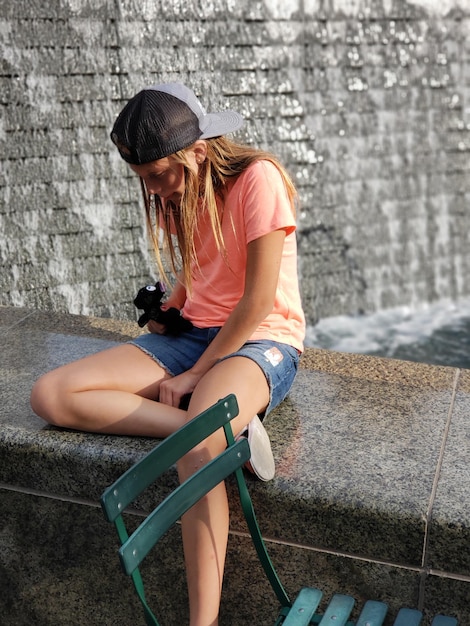 Photo girl sitting on retaining wall