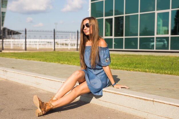 Photo girl sitting on street in summer day.