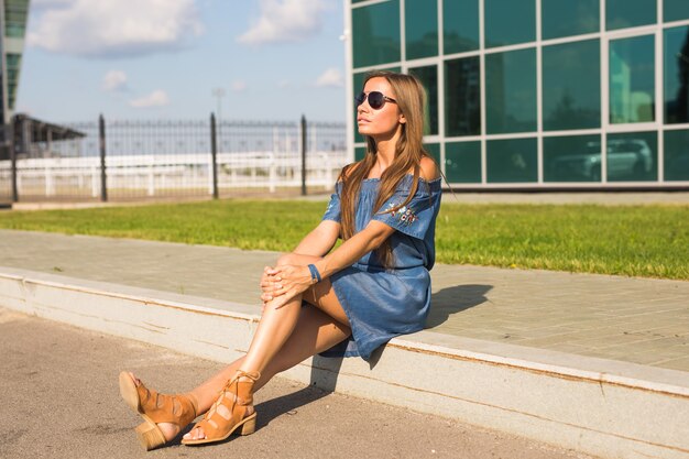 Photo girl sitting on street in summer day.