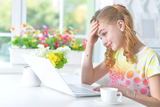 Girl sitting at table with laptop