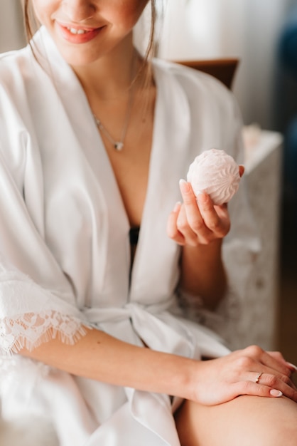 Girl sitting with marshmallows in light clothes