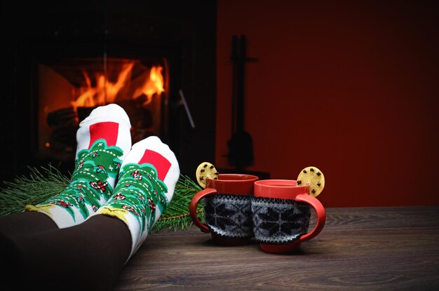 Girl in slippers cup on vintage wood near fireplace