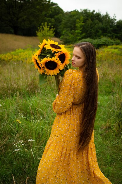 Girl smelling a sunflower in a field