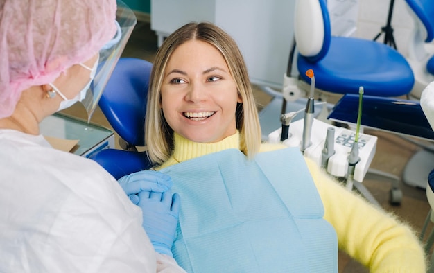 The girl smiles at the dentist and looks at her